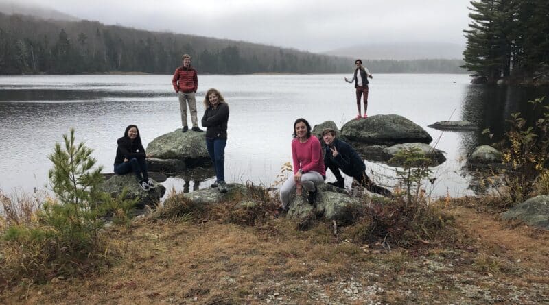 Kids standing on rocks by river