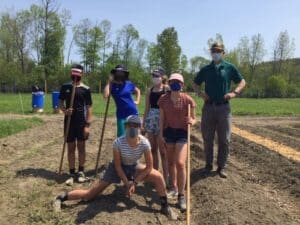 Kids standing over a ditch, digging