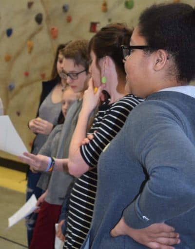 young people studying a display on the wall