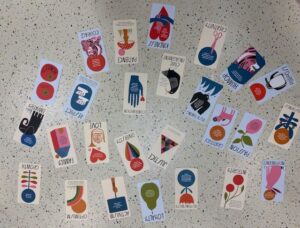 Playing cards describing personality traits and guiding principles laid in a pattern.